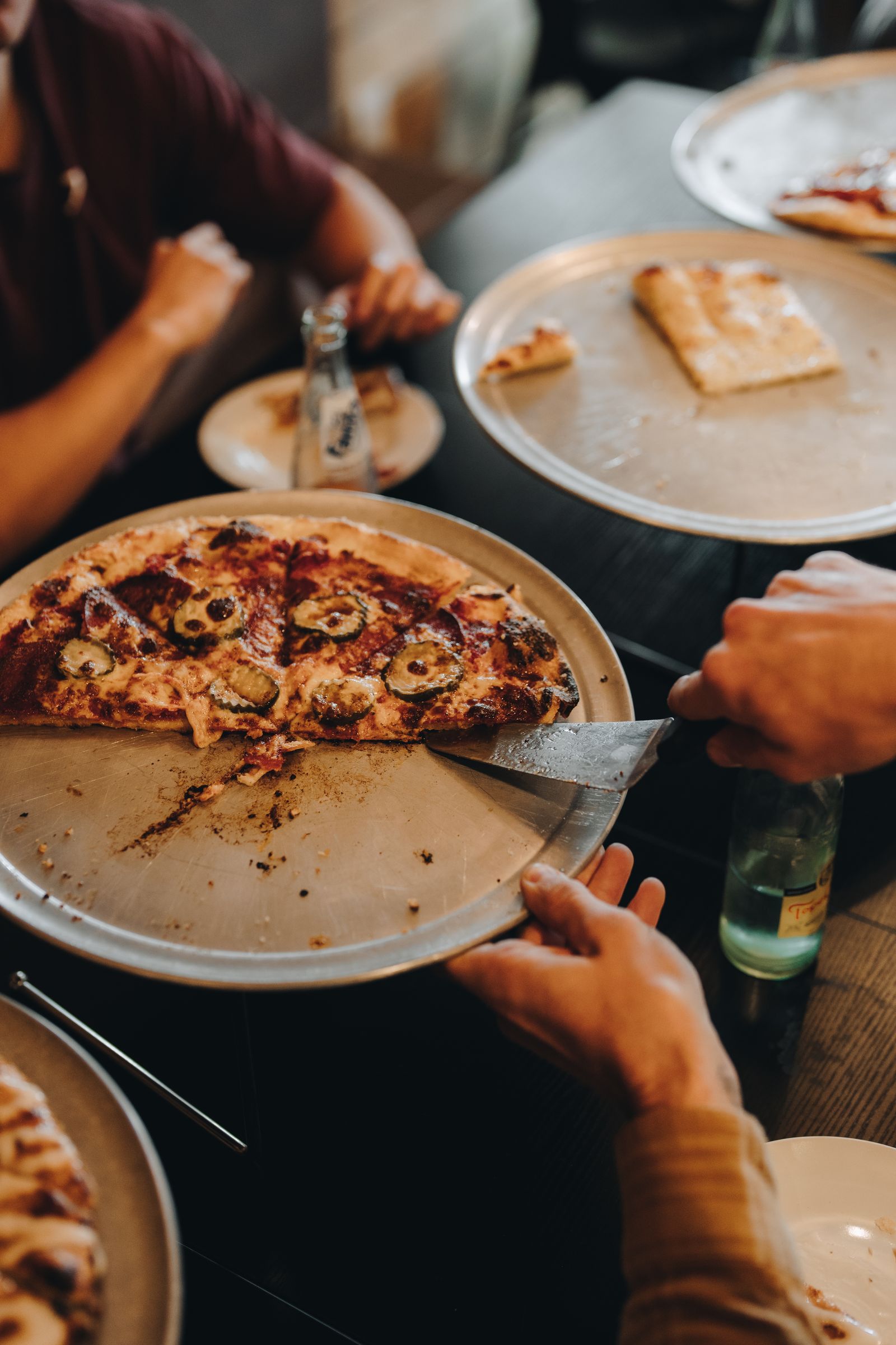 A jalapeño pizza being sliced at Blue Buffalo Pizzeria